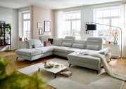 Moderne Polsterrundecke in hellem Grau in einem stilvoll eingerichteten Wohnzimmer, seitliche Perspektive.