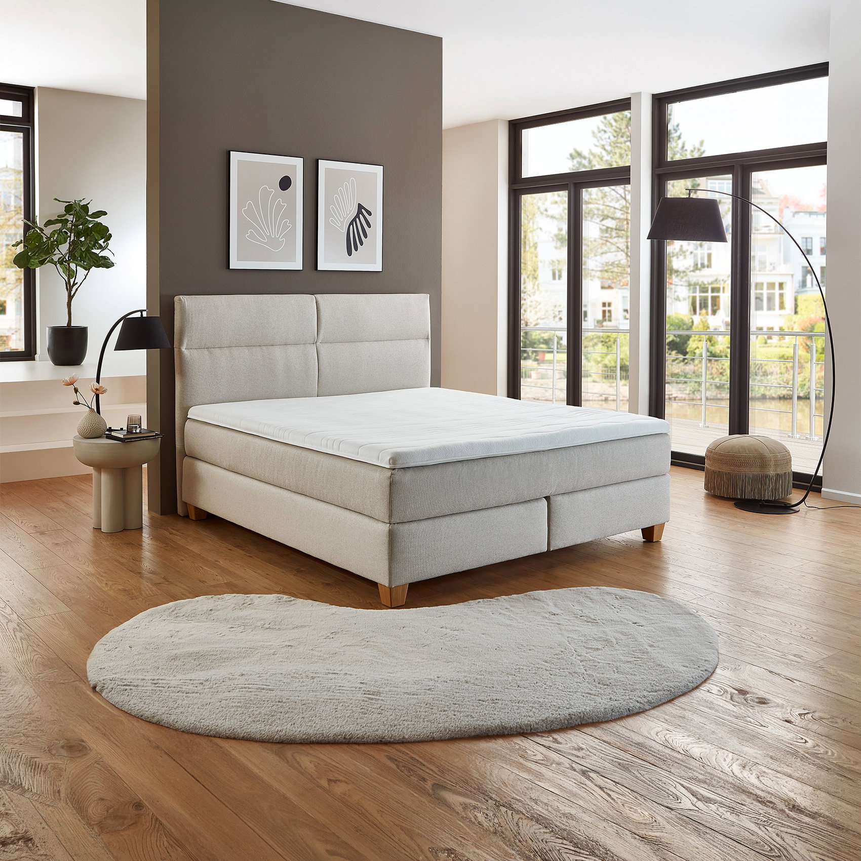 Modernes Schlafzimmer mit Boxspringbett, großen Fenstern, Holzfußboden und minimalistischem Dekor