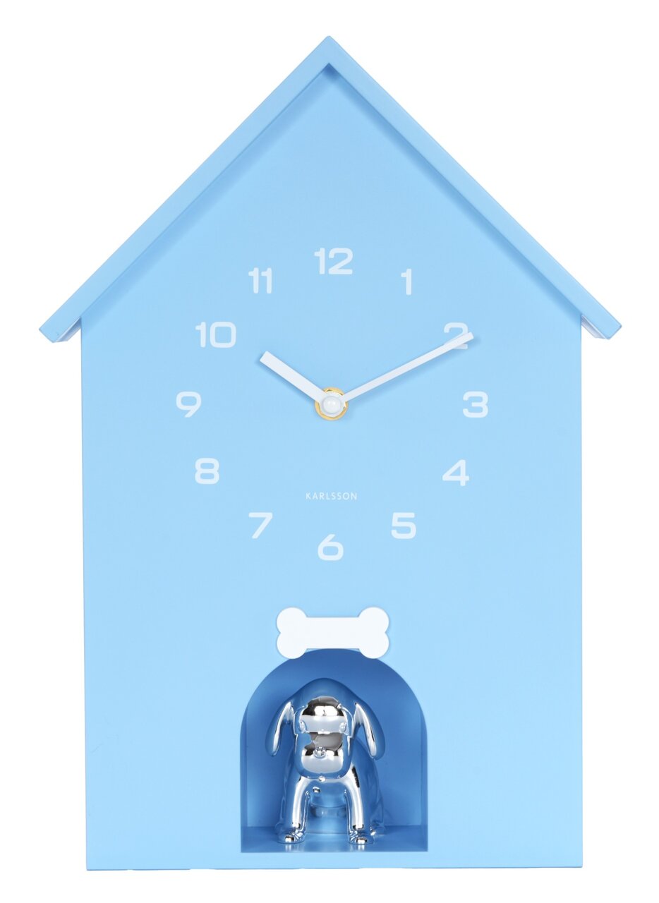 Blaue Wanduhr in Form eines Hauses mit weißen Ziffern und Zeigern, darunter eine silberne Hundefigur in einer kleinen Nische. Frontalansicht.