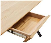 Nahaufnahme eines Schreibtisches aus hellem Holz mit geöffneter Schublade, von oben betrachtet.