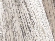 Nahaufnahme eines Designer Teppichs mit abstraktem Muster in Grautönen, seitliche Perspektive