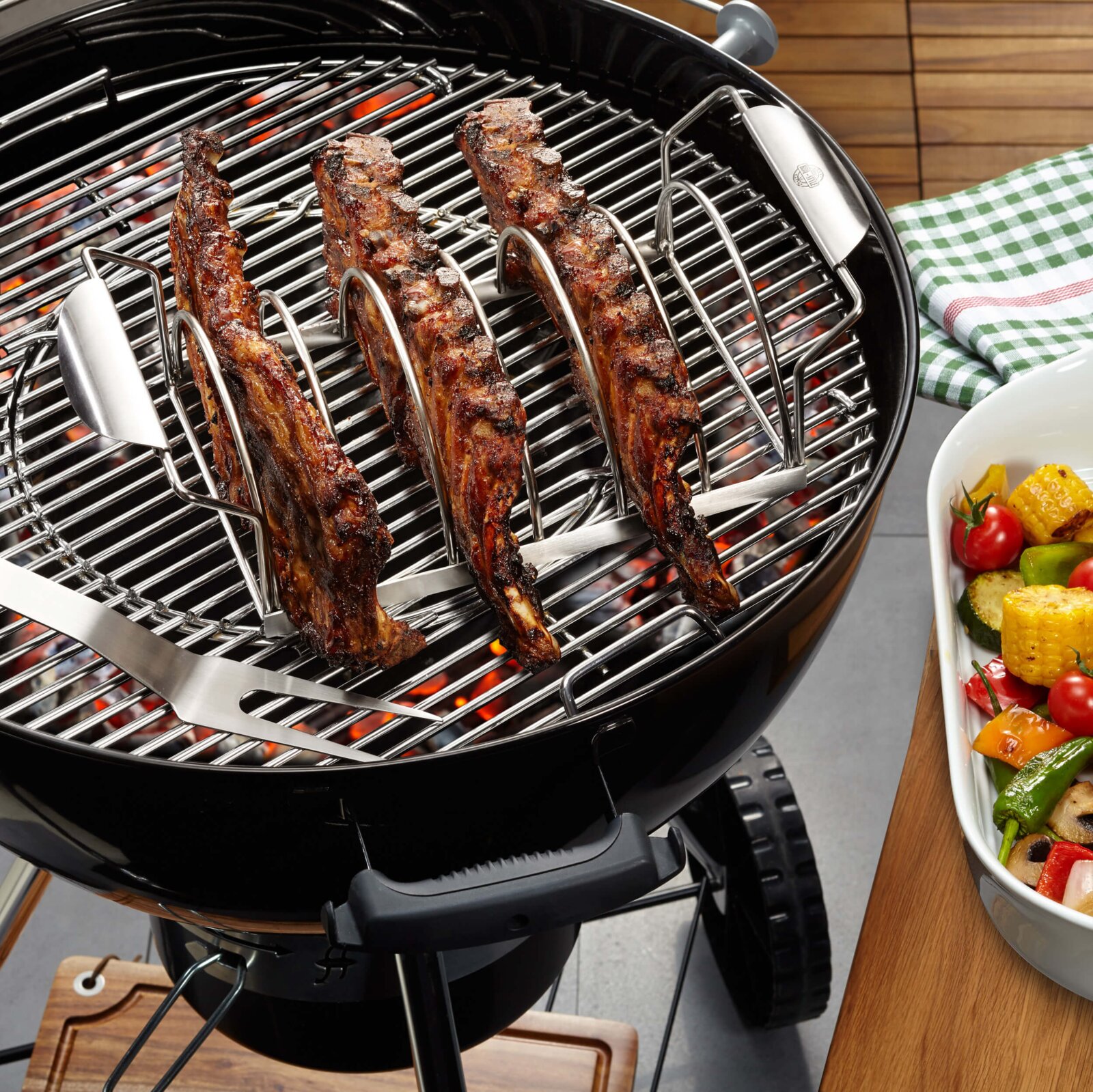Ribhouder op een barbecue met gegrilde ribbetjes, zijaanzicht