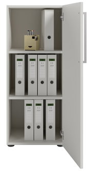 Aktenschrank mit geöffneter Tür, gefüllt mit Ordnern und Bürobedarf, Perspektive von vorne.