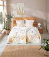 Bettwäsche-Set mit floralen Mustern in einem hellen, modernen Schlafzimmer, aus der Perspektive von vorne aufgenommen.