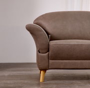 Nahaufnahme eines braunen Sofas mit Holzbeinen, seitliche Perspektive