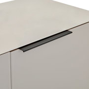 Schwarzer, minimalistischer Griff an weißer Schubladenfront, Detailaufnahme aus schräger Seitenansicht von oben