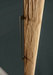 Nahaufnahme eines Drehtürenschranks mit einer Kombination aus Holz- und dunklen Oberflächen, seitliche Perspektive.