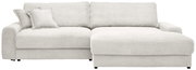 Beiges Cord-Ecksofa mit Recamiere rechts, breiten Armlehnen und zwei Zierkissen, frontal aus leicht erhöhter Perspektive vor weißem Hintergrund.