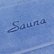 Nahaufnahme eines blauen Saunatuchs mit gesticktem Schriftzug 'Sauna'.