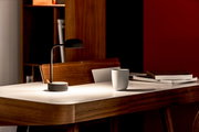 Moderne Tischlampe in Anthrazit auf einem eleganten Holztisch, seitliche Perspektive