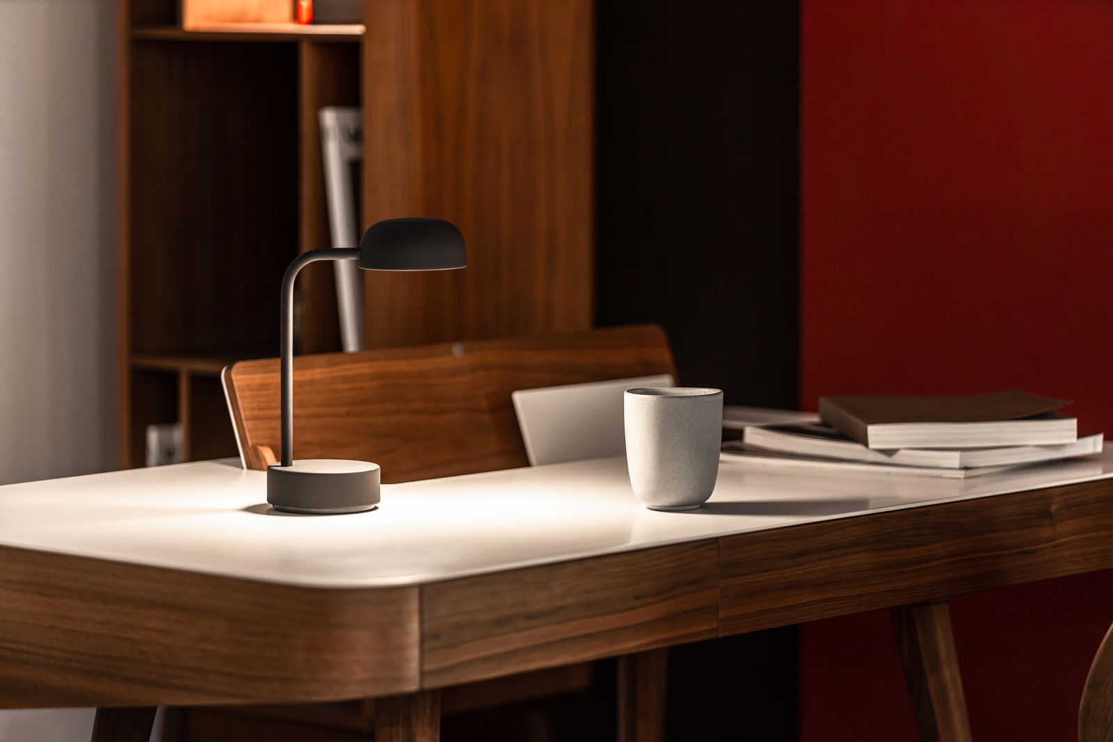 Moderne Tischlampe in Anthrazit auf einem eleganten Holztisch, seitliche Perspektive