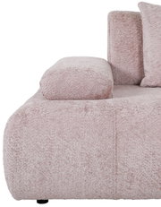 Nahaufnahme eines rosa Sofas mit weicher, texturierter Oberfläche und Armlehne, seitliche Perspektive
