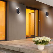 Moderne anthrazitfarbene Wand- und Deckenleuchte an der Außenfassade eines Hauses, seitliche Perspektive