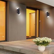 Moderne anthrazitfarbene Wand- und Deckenleuchte an der Außenfassade eines Hauses, seitliche Perspektive