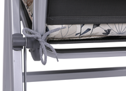 Nahaufnahme einer Hochlehnerauflage mit floralem Muster, befestigt an einem Metallrahmen. Perspektive von der Seite.