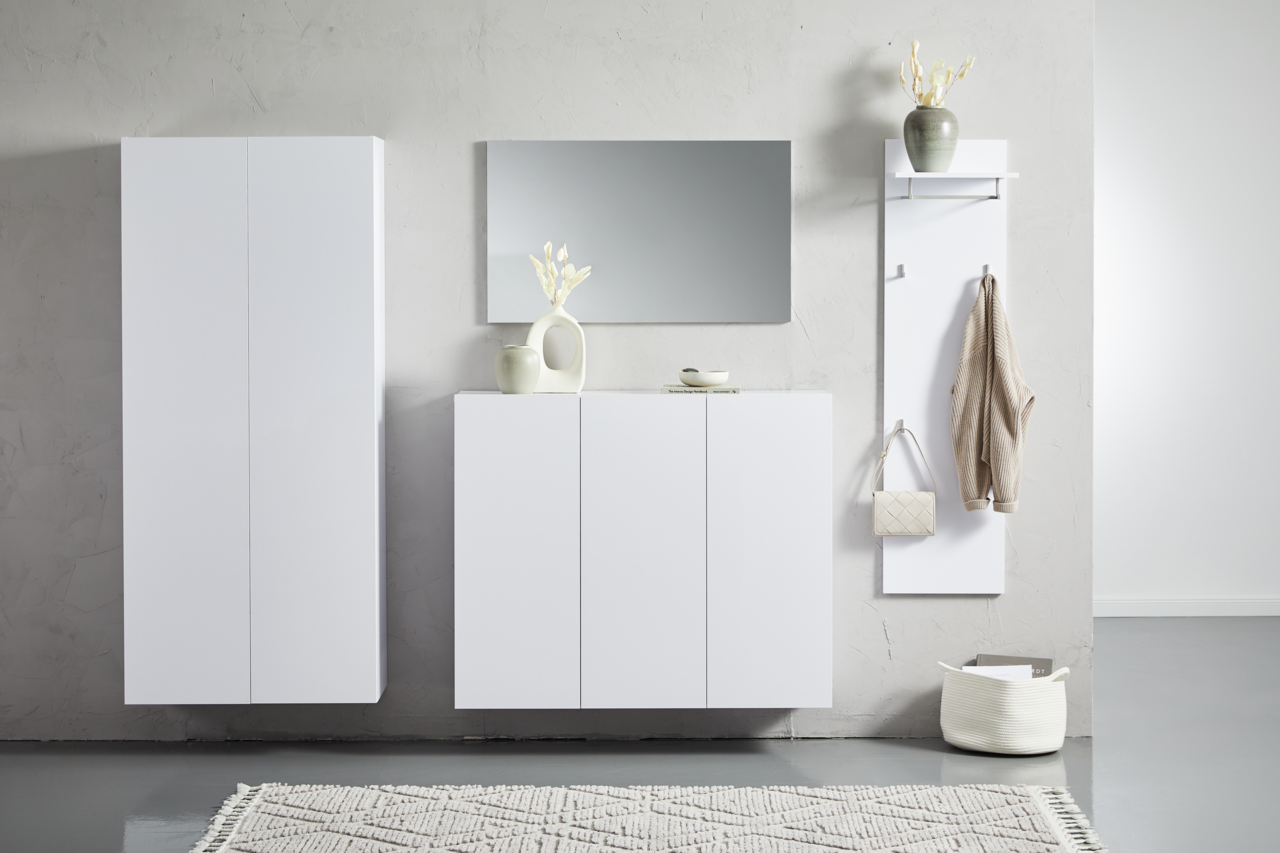 Moderne weiße Hängemöbel in einem minimalistischen Raum, frontal betrachtet. Links ein hoher Schrank, in der Mitte ein Sideboard mit Dekoration und rechts eine Garderobe mit Haken.