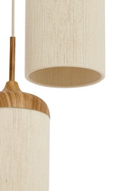 Detailaufnahme einer hängenden Pendelleuchte mit zylindrischem, cremefarbenem Stoffschirm und Holzdetails, seitliche Perspektive