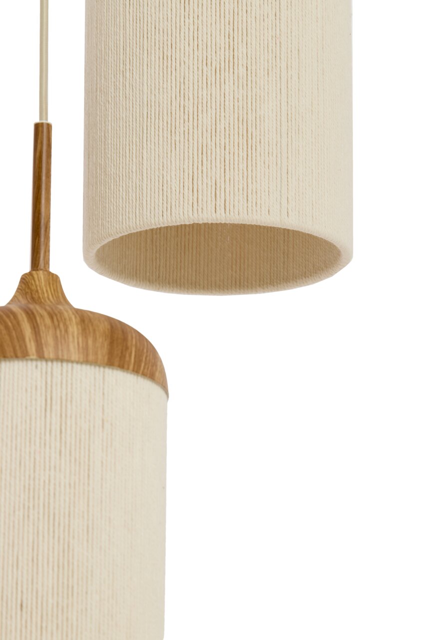 Detailaufnahme einer hängenden Pendelleuchte mit zylindrischem, cremefarbenem Stoffschirm und Holzdetails, seitliche Perspektive