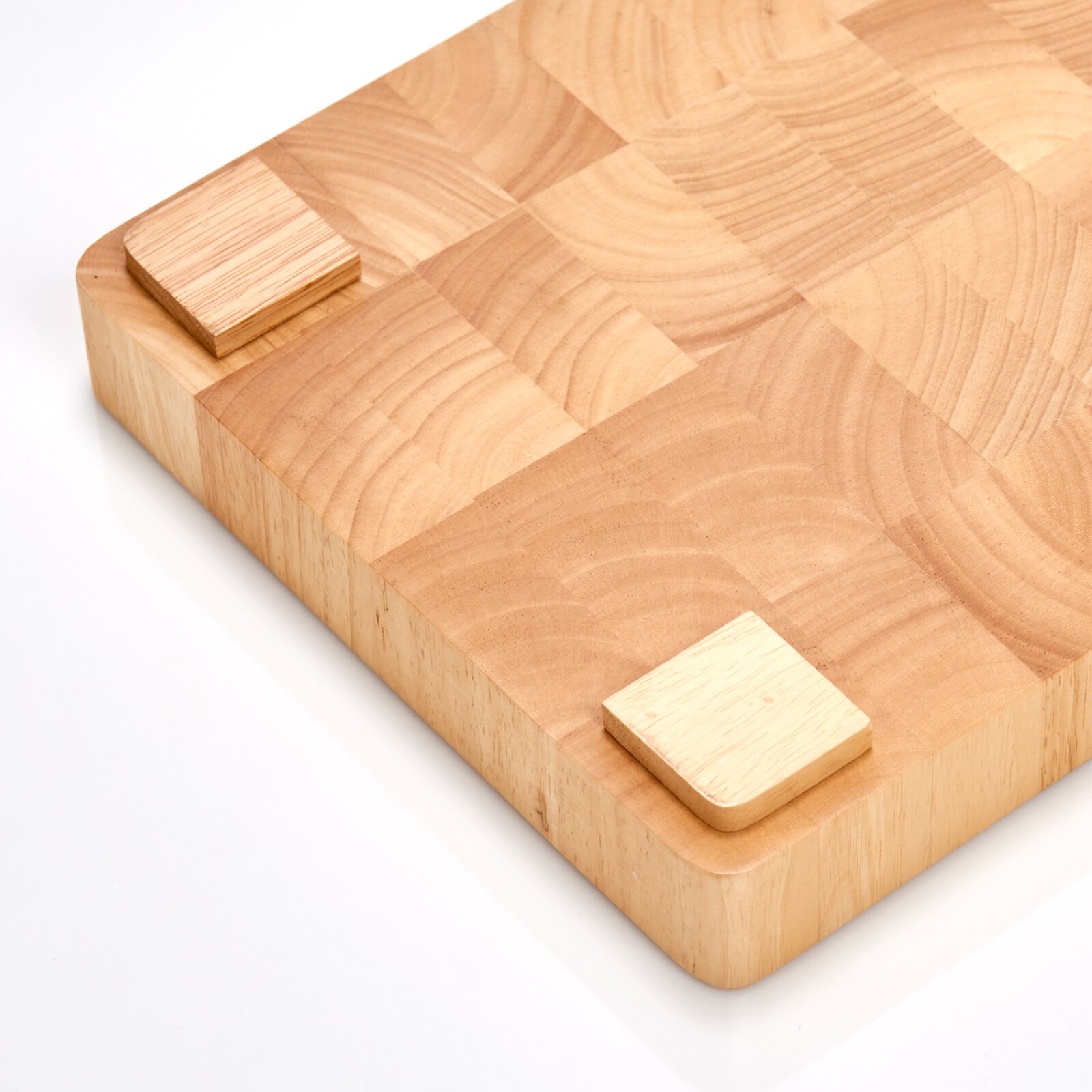 Holz-Hackblock in Nahaufnahme, perspektivisch von oben fotografiert, zeigt die Maserung und die quadratische Form mit abgerundeten Ecken.