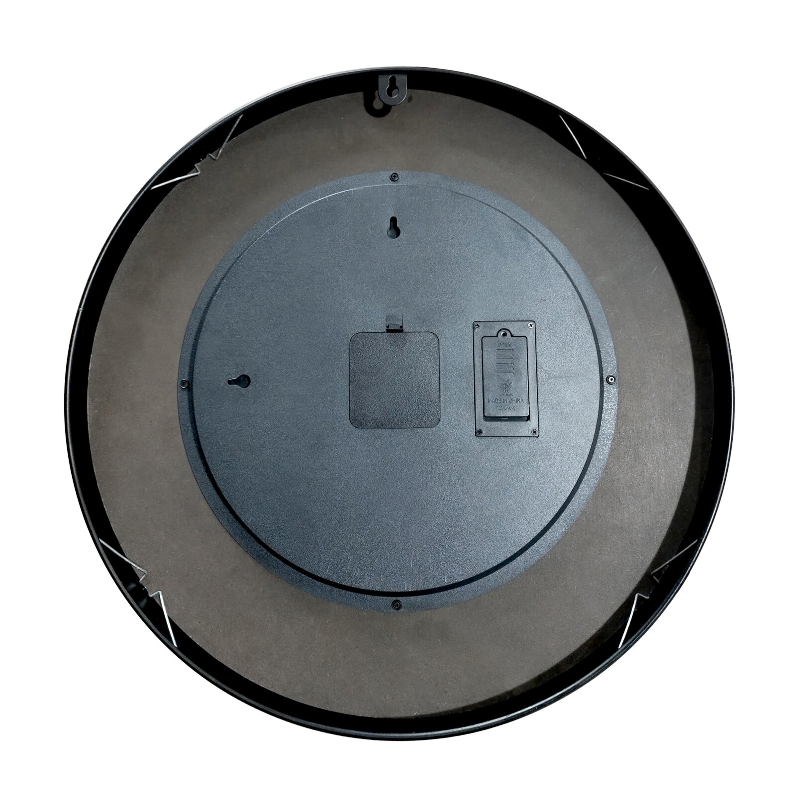 Achterkant van een ronde wandklok in het zwart, met ophanghaak en batterijvak, op een witte achtergrond