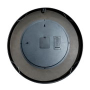 Achterkant van een ronde wandklok in het zwart, met ophanghaak en batterijvak, op een witte achtergrond