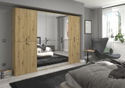Moderne Garderobenkombination mit Holzoptik und Spiegeltüren, frontal im Schlafzimmer platziert.