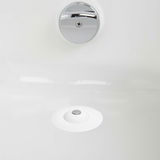 Blick von oben auf einen weißen Haarfänger und Wasserstopper in einem Waschbecken.