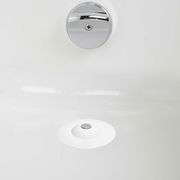 Blick von oben auf einen weißen Haarfänger und Wasserstopper in einem Waschbecken.