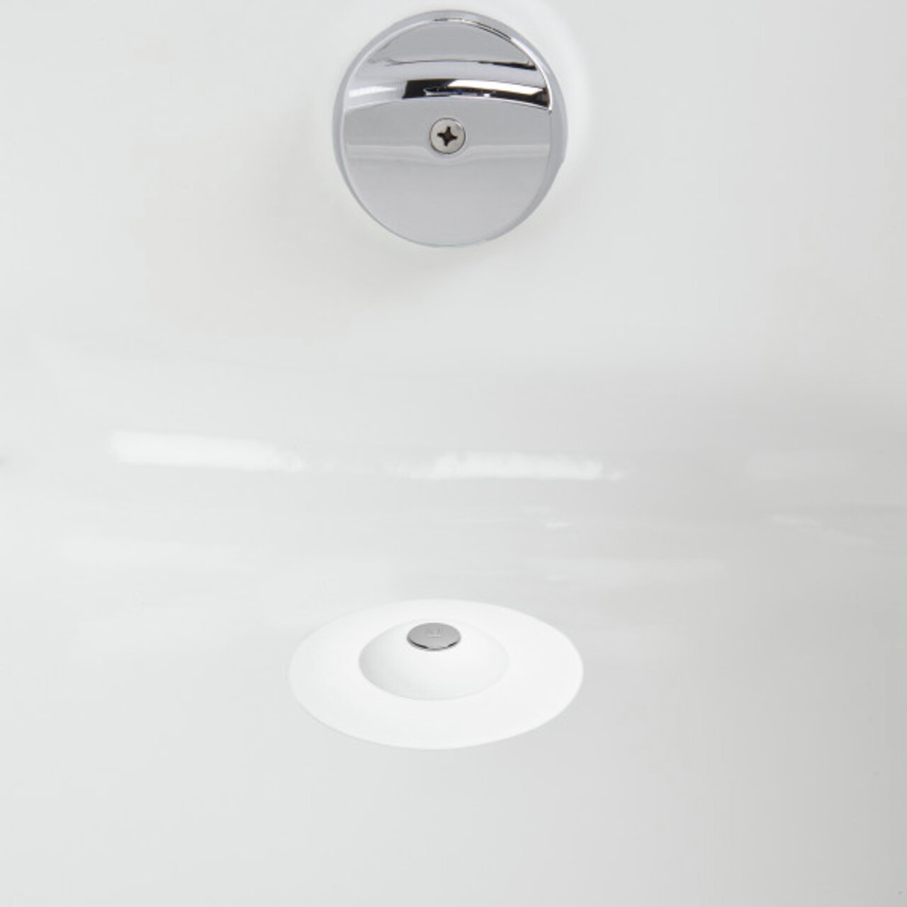 Blick von oben auf einen weißen Haarfänger und Wasserstopper in einem Waschbecken.