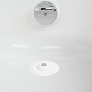 Blick von oben auf einen weißen Haarfänger und Wasserstopper in einem Waschbecken.