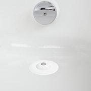 Blick von oben auf einen weißen Haarfänger und Wasserstopper in einem Waschbecken.