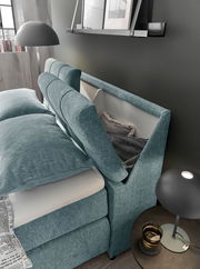 Boxspringbett mit Stauraum im Kopfteil, seitliche Perspektive, modernes Design in Türkis