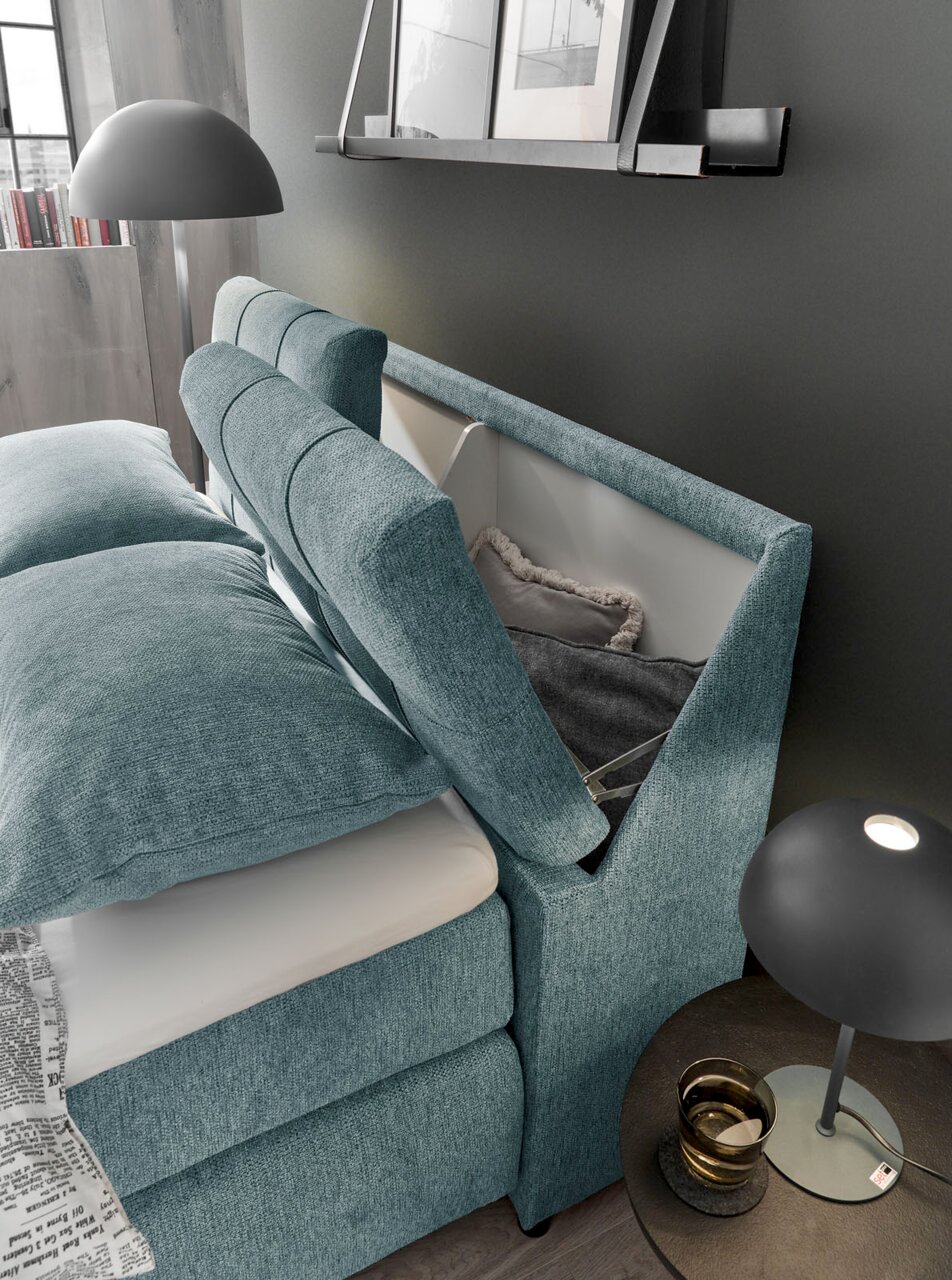 Boxspringbett mit Stauraum im Kopfteil, seitliche Perspektive, modernes Design in Türkis