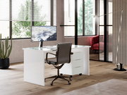 Moderner weißer Schreibtisch mit Glasplatte und Rollcontainer, seitliche Perspektive in einem stilvollen Büro mit großen Fenstern.