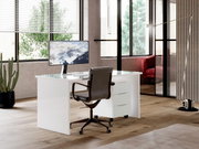 Moderner weißer Schreibtisch mit Glasplatte und Rollcontainer, seitliche Perspektive in einem stilvollen Büro mit großen Fenstern.