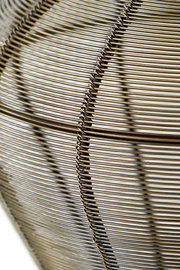 Nahaufnahme einer Hängeleuchte mit einem filigranen, metallischen Drahtdesign in seitlicher Perspektive.