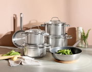 Topfset ELEGANCE 6-tlg. aus Edelstahl, bestehend aus mehreren Töpfen und Pfannen, auf einer Küchenarbeitsplatte arrangiert. Perspektive von vorne.