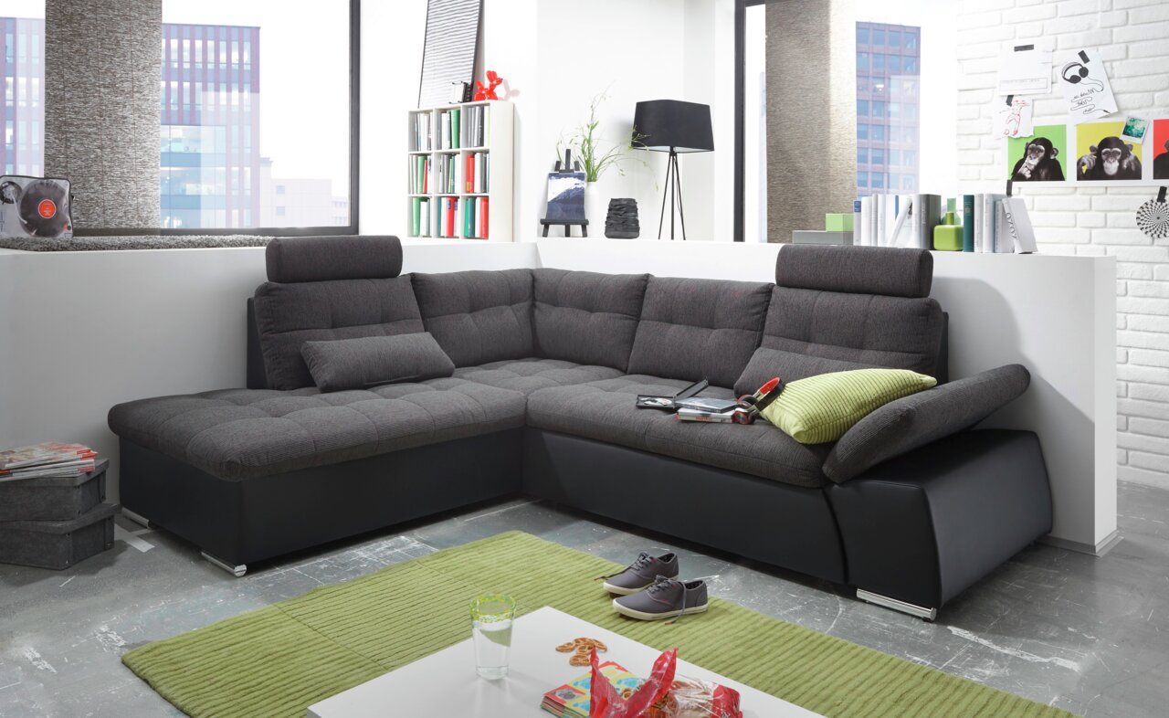 Moderne Rundecke in dunklem Stoff mit verstellbaren Kopfstützen, abgebildet in einem stilvollen Wohnzimmer aus der Frontalperspektive.