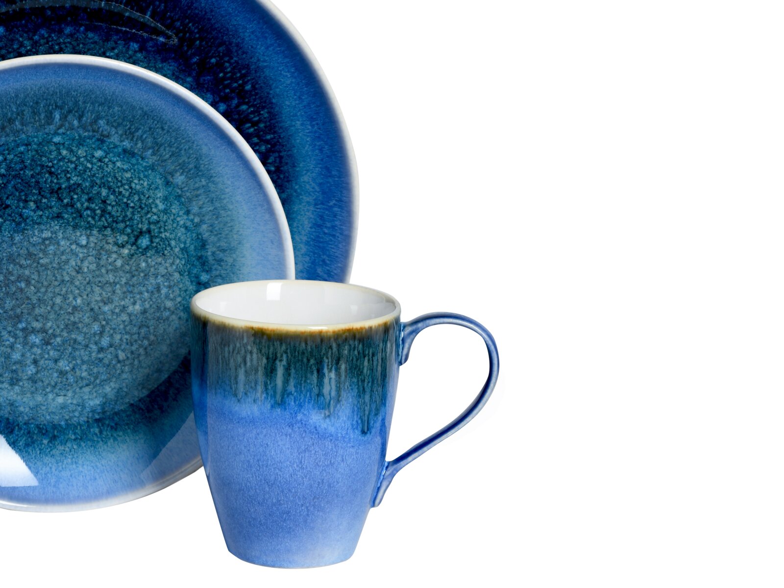 Blau glasiertes Keramik-Geschirrset mit Tasse und zwei Tellern, freigestellt vor weißem Hintergrund, Ansicht schräg von vorne (Tasse im Vordergrund, Teller dahinter)