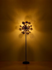 Moderne Stehleuchte mit kugelförmigem Design, beleuchtet in einem warmen, goldenen Licht, frontal betrachtet.