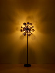 Moderne Stehleuchte mit kugelförmigem Design, beleuchtet in einem warmen, goldenen Licht, frontal betrachtet.