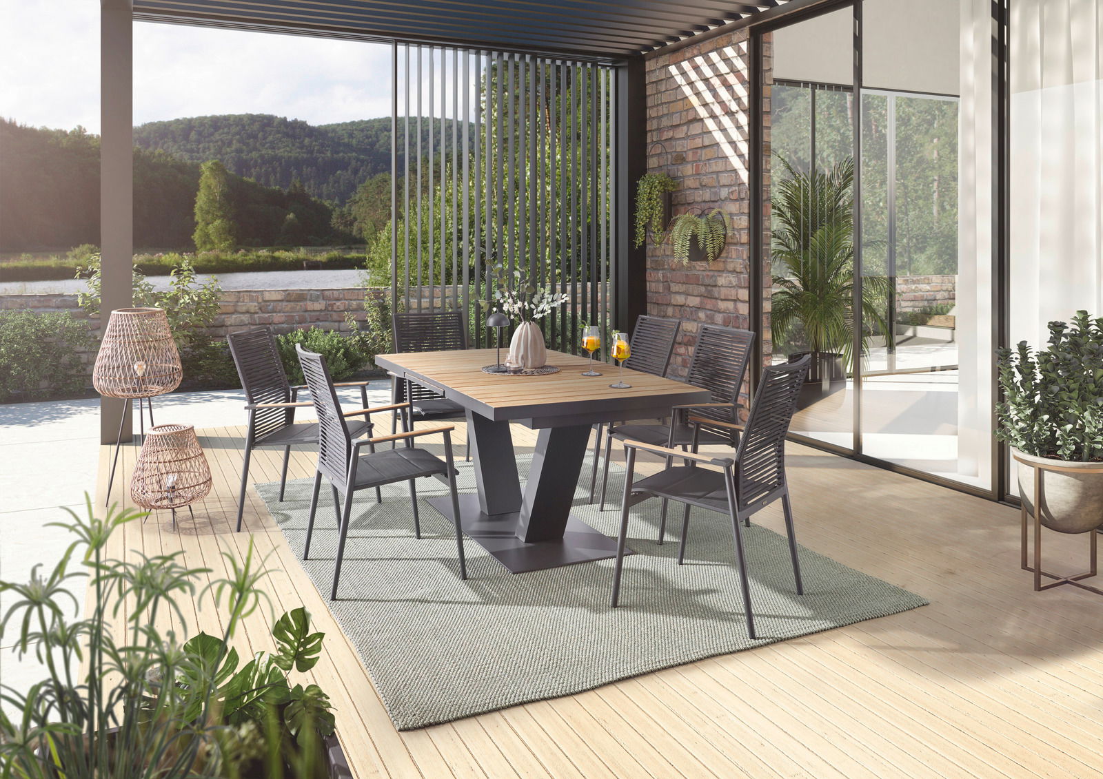 Moderner Essbereich im Freien mit stilvollen Sesseln und einem Tisch auf einer Terrasse mit Blick auf die Natur, aus seitlicher Perspektive.