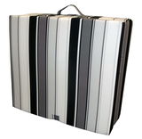 Faltmatratze mit schwarz-weißen Streifen, zusammengeklappt und mit Tragegriff, seitliche Perspektive