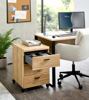 Rollcontainer aus Holz mit drei Schubladen, auf Rollen, in einem modernen Büro neben einem Schreibtisch, Perspektive von vorne links