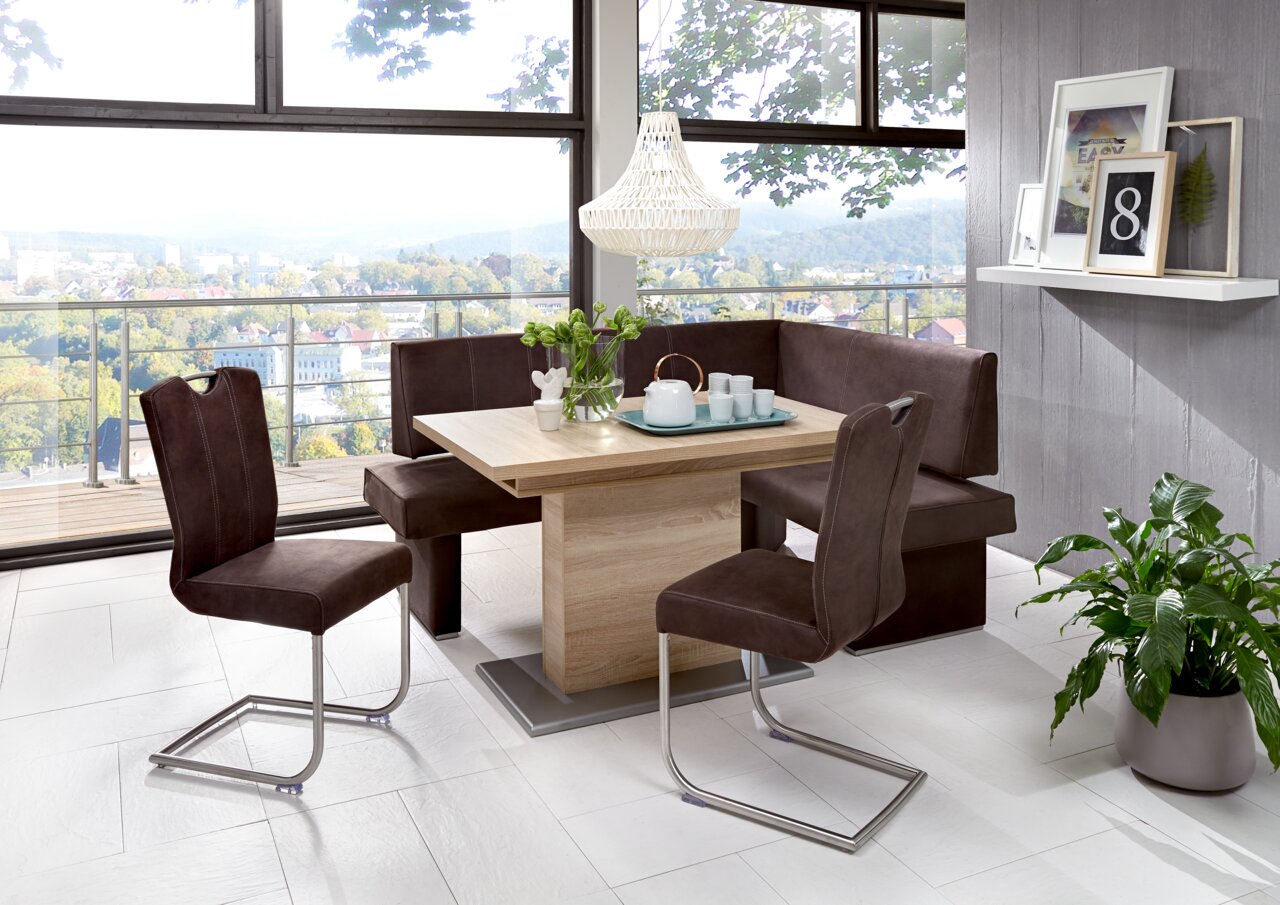 Esszimmer mit modernem Freischwinger-Stuhlset und Eckbank in braunem Stoff, Holztisch und Panoramablick aus dem Fenster, seitliche Perspektive