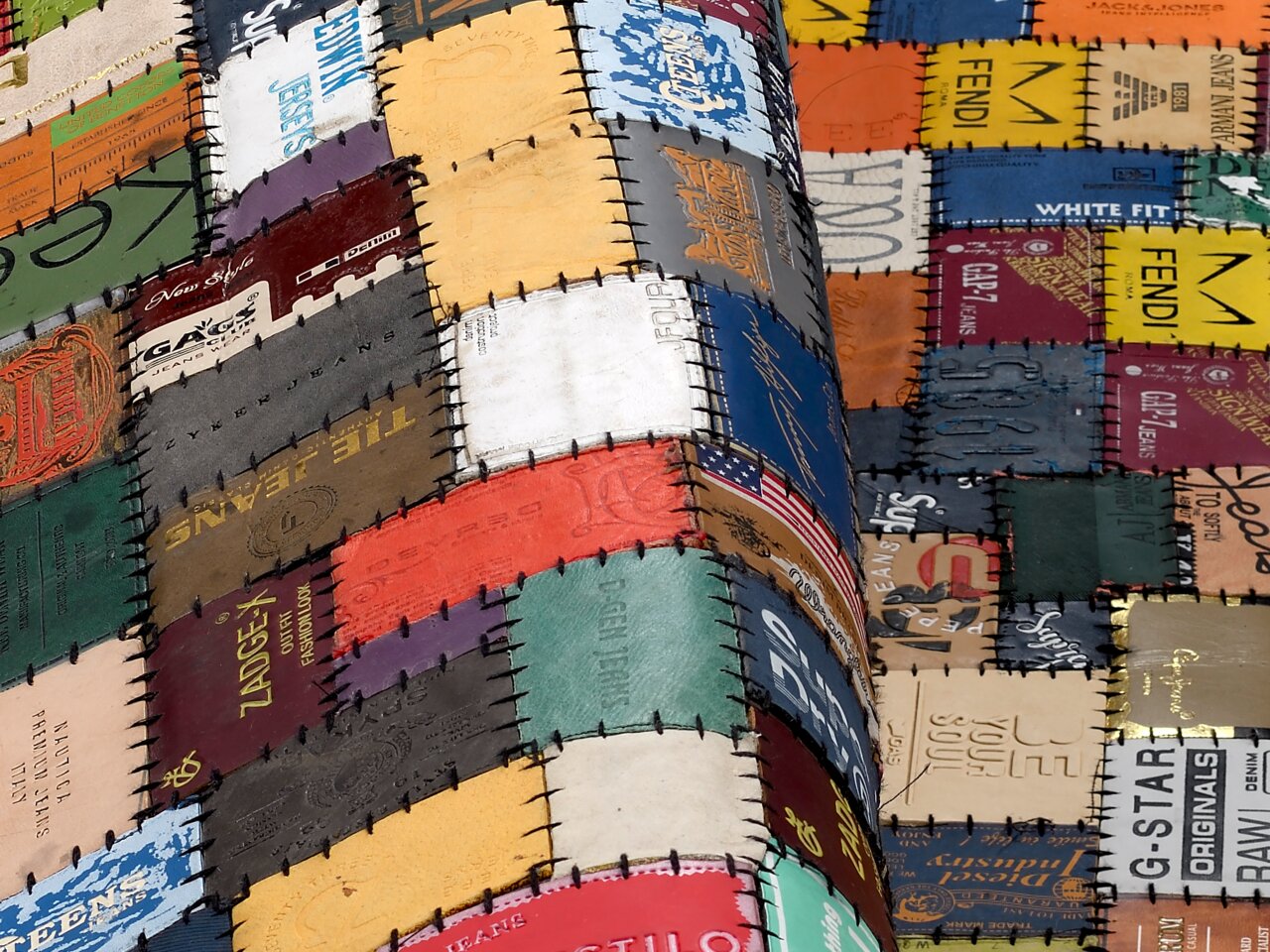 Patchwork-Lederteppich aus verschiedenen bunten Etiketten, perspektivisch von der Seite aufgenommen.