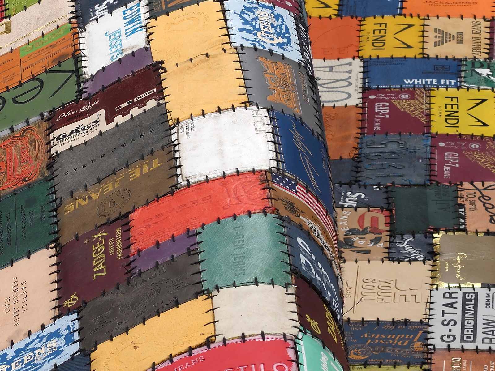 Patchwork-Lederteppich aus verschiedenen bunten Etiketten, perspektivisch von der Seite aufgenommen.