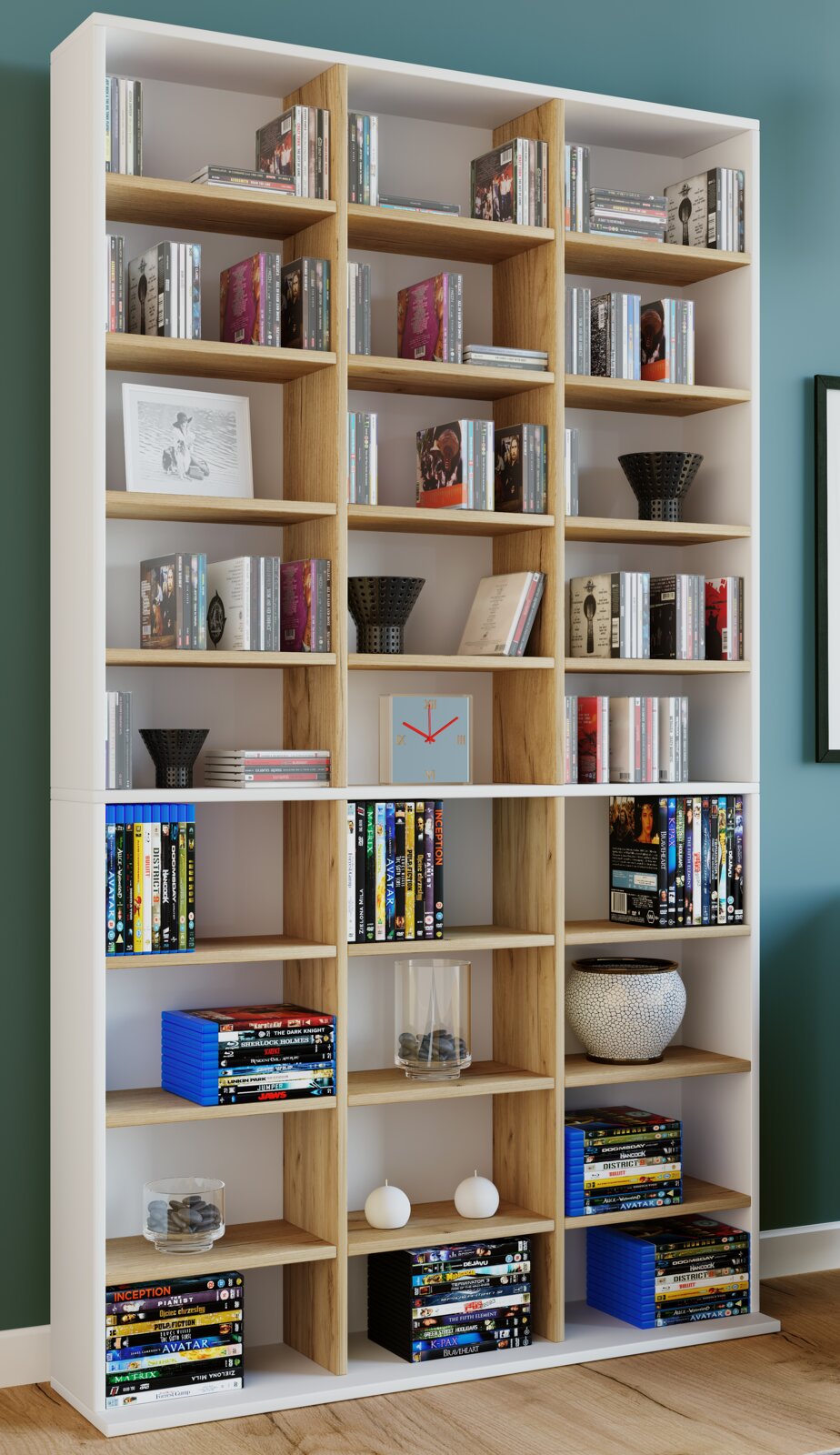 Modernes, hohes Regal in Weiß mit Eiche-Holzoptik und vielen Fächern, gefüllt mit CDs, DVDs und Deko, frontal aus leicht schräger Perspektive fotografiert.