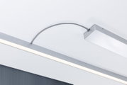 Moderne, schlanke LED-Deckenleuchte in Silber mit linearem Lichtband und gebogenem Anschlusskabel, fotografiert aus der Untersicht schräg von unten