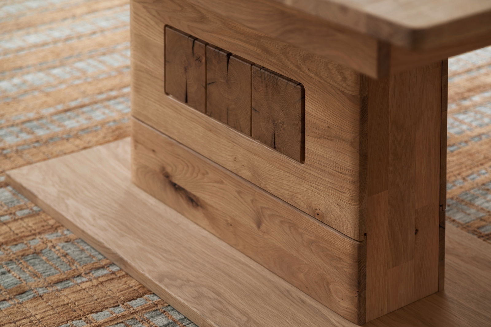 Detailansicht eines Couchtischs aus Holz mit natürlicher Maserung und dekorativen Elementen, seitliche Perspektive.